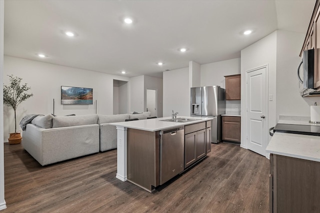 kitchen featuring appliances with stainless steel finishes, sink, dark hardwood / wood-style flooring, and a kitchen island with sink