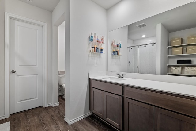 bathroom with walk in shower, wood-type flooring, toilet, and vanity