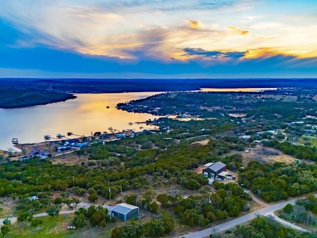 aerial view at dusk featuring a water view