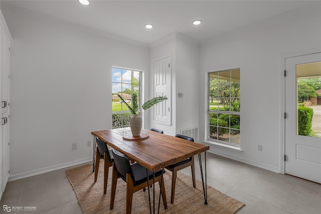 dining area with ornamental molding and light tile patterned floors