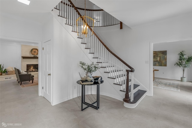 staircase with crown molding and a premium fireplace