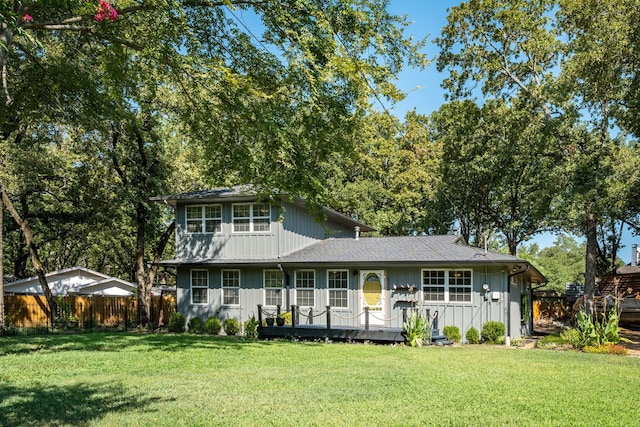 view of front of home with a deck and a front lawn