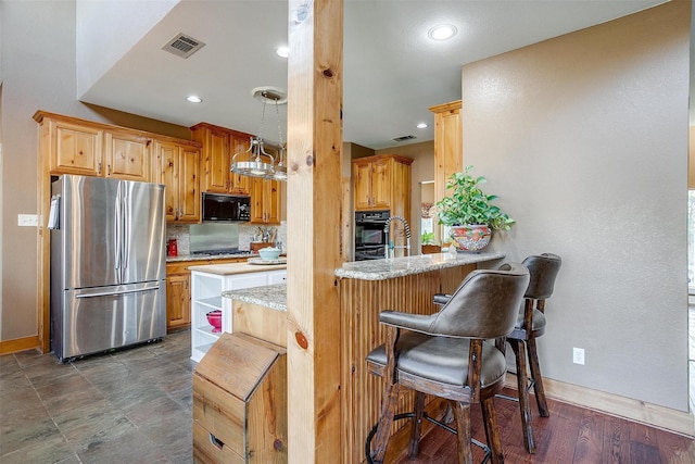 kitchen featuring a breakfast bar, pendant lighting, kitchen peninsula, stainless steel appliances, and light stone countertops