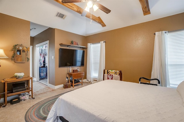 carpeted bedroom featuring ceiling fan, a walk in closet, lofted ceiling, and a closet