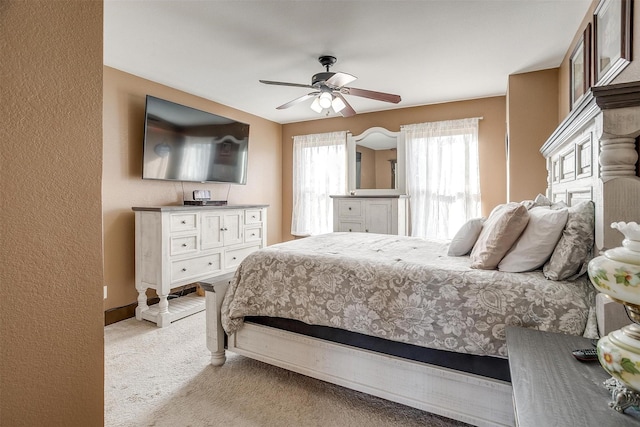 bedroom with ceiling fan and light carpet