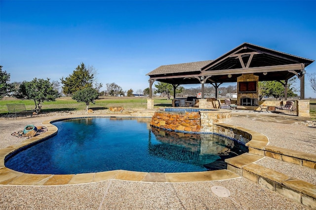 view of swimming pool featuring a gazebo and exterior fireplace