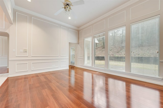 interior space with hardwood / wood-style flooring, ornamental molding, and ceiling fan