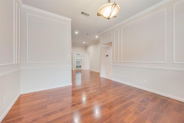 spare room featuring hardwood / wood-style flooring and ornamental molding