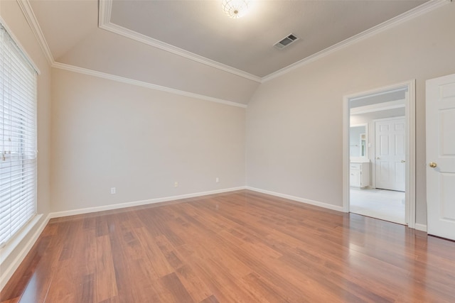 unfurnished room with hardwood / wood-style flooring, crown molding, and vaulted ceiling