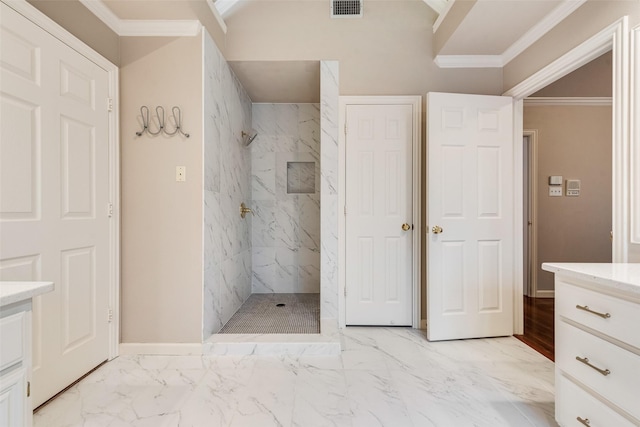 bathroom featuring vanity, ornamental molding, and tiled shower