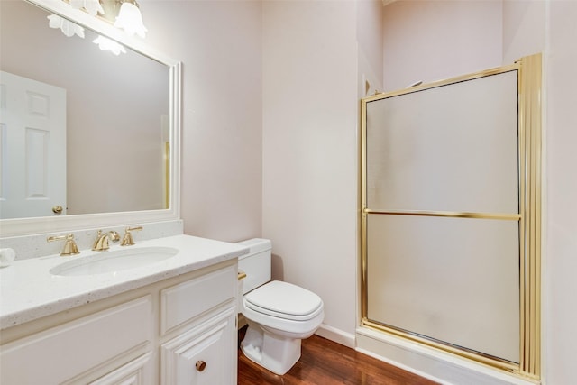 bathroom with walk in shower, vanity, toilet, and hardwood / wood-style flooring