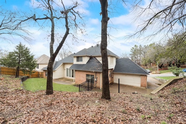 rear view of property with a yard and a garage