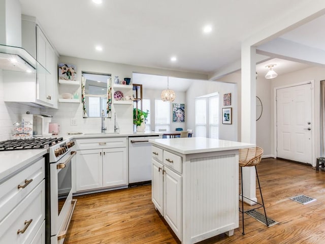 7010 San Mateo Blvd, Dallas, TX 75223 - kitchen featuring white appliances, open shelves, a breakfast bar, light wood-style floors, and recessed lighting