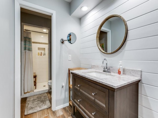 7010 San Mateo Blvd, Dallas, TX 75223 - full bathroom with wood finished floors, toilet, vanity, and a tile shower