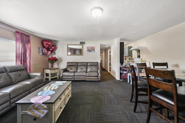 living area featuring visible vents, dark carpet, and a textured ceiling