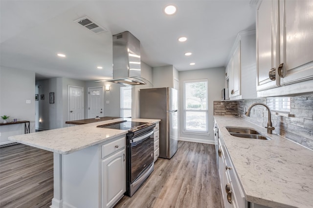 kitchen with white cabinets, island exhaust hood, visible vents, and appliances with stainless steel finishes