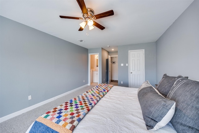 carpeted bedroom with a ceiling fan, ensuite bath, visible vents, and baseboards