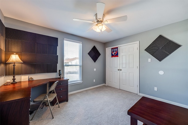 home office with light carpet, ceiling fan, and baseboards