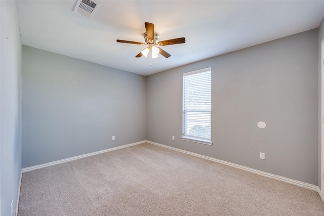 spare room featuring ceiling fan, baseboards, visible vents, and light colored carpet