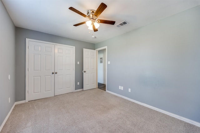 unfurnished bedroom featuring light colored carpet, a closet, visible vents, and baseboards