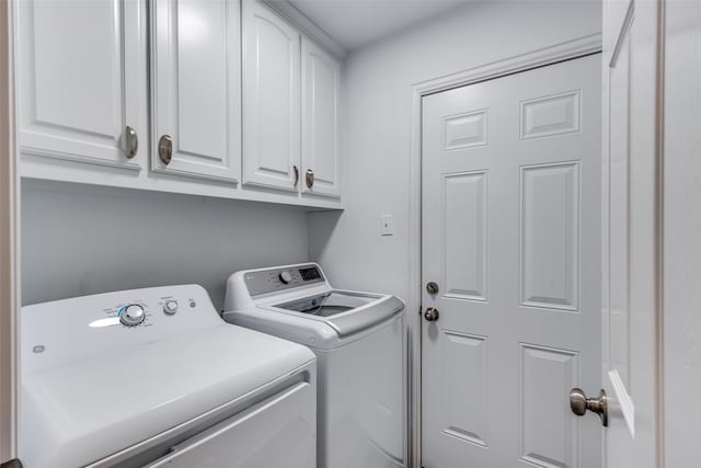 washroom featuring washing machine and dryer and cabinet space