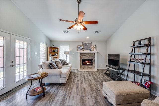 living area with lofted ceiling, french doors, visible vents, and wood finished floors