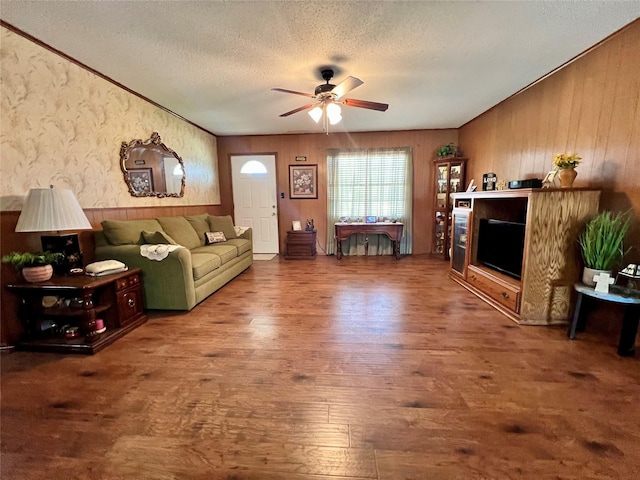 living room featuring ceiling fan, hardwood / wood-style floors, and a textured ceiling