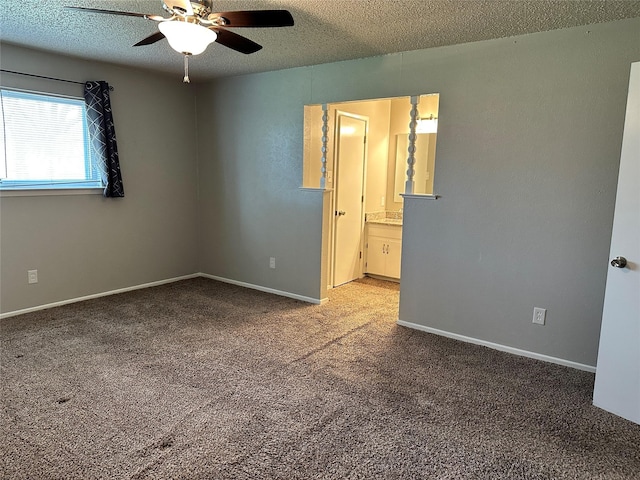 unfurnished bedroom featuring baseboards, a ceiling fan, ensuite bathroom, carpet, and a textured ceiling