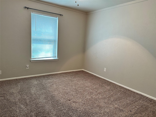 unfurnished room with carpet floors, ornamental molding, and baseboards