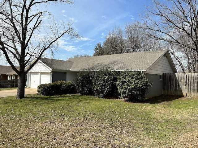 ranch-style house with a shingled roof, concrete driveway, fence, a garage, and a front lawn