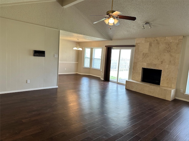 unfurnished living room featuring a large fireplace, vaulted ceiling, dark wood-style floors, and a textured ceiling