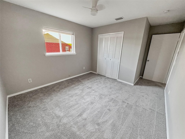 unfurnished bedroom with light colored carpet, ceiling fan, and a closet