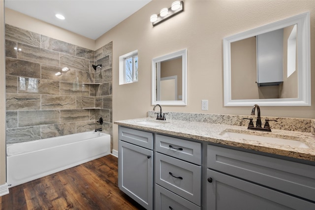 bathroom featuring tiled shower / bath, wood-type flooring, and vanity