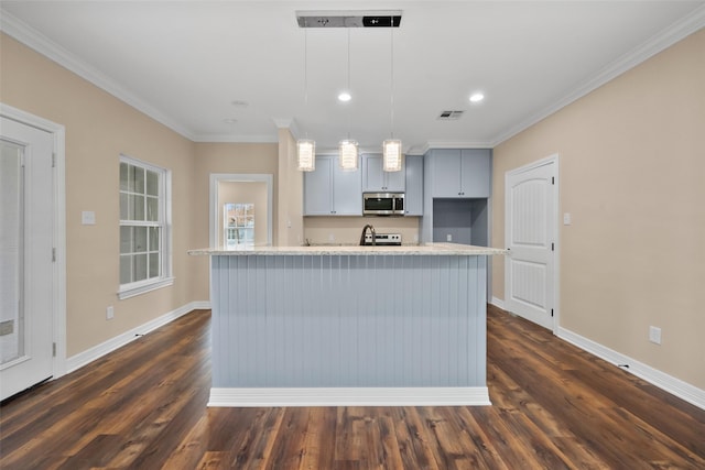 kitchen with crown molding, appliances with stainless steel finishes, a kitchen island with sink, and decorative light fixtures