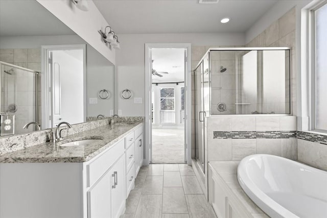 bathroom featuring ceiling fan, vanity, and shower with separate bathtub