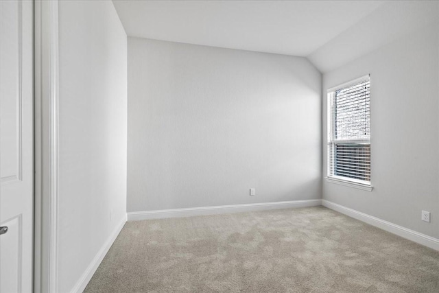 carpeted empty room with lofted ceiling