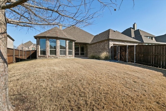 rear view of house featuring a yard