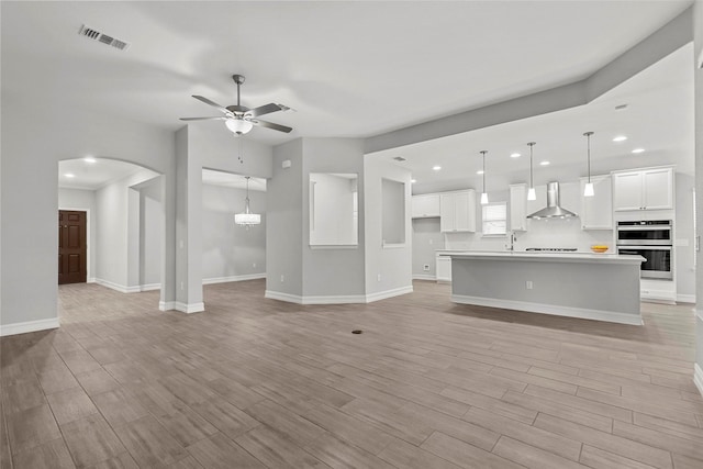 2700 Wallingford Dr, Mansfield, TX 76084 - unfurnished living room with ceiling fan, arched walkways, recessed lighting, baseboards, and light wood finished floors