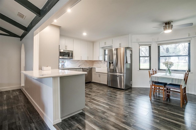 kitchen featuring appliances with stainless steel finishes, a breakfast bar area, white cabinets, and kitchen peninsula