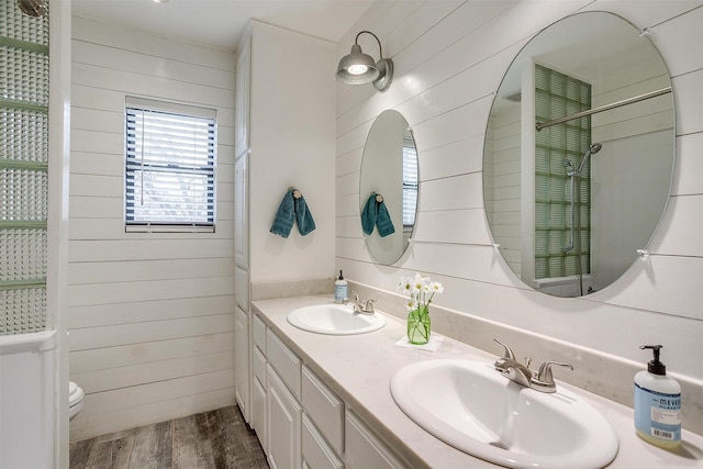 bathroom featuring wood-type flooring, vanity, wood walls, and toilet