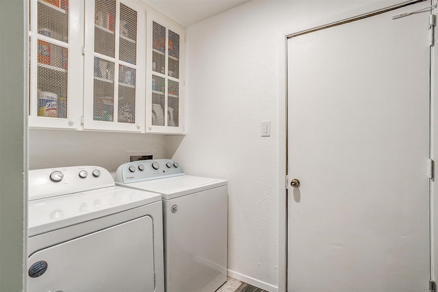 washroom featuring washing machine and dryer and cabinets