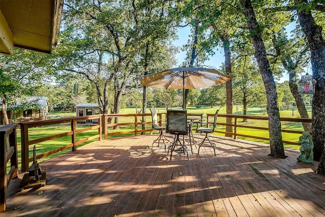 wooden deck featuring a storage unit and a lawn