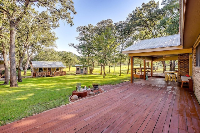 wooden deck with a yard and an outdoor structure