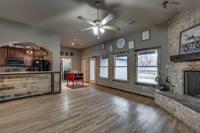 living room featuring wood-type flooring, ceiling fan, and a fireplace