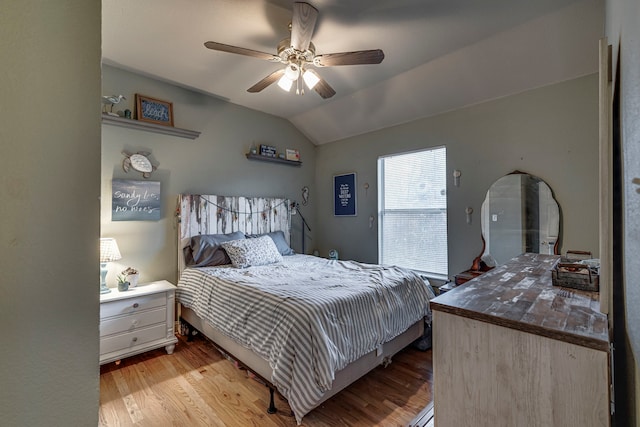 bedroom featuring ceiling fan, lofted ceiling, and light wood-type flooring