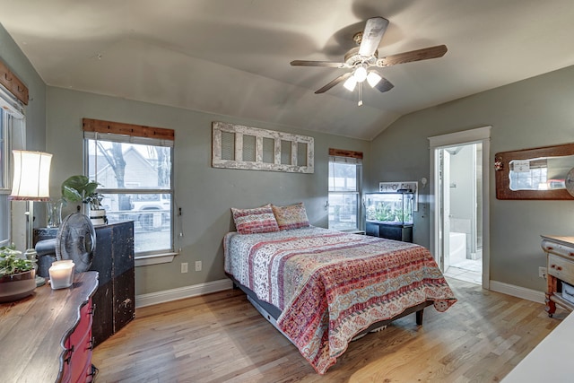 bedroom featuring vaulted ceiling, ceiling fan, ensuite bathroom, and light hardwood / wood-style floors