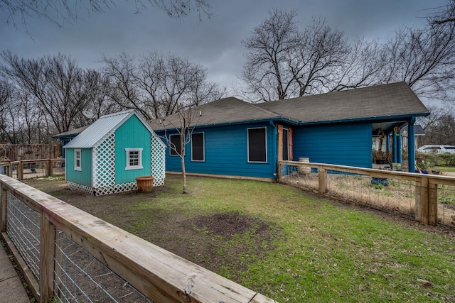 rear view of house with a yard and an outbuilding