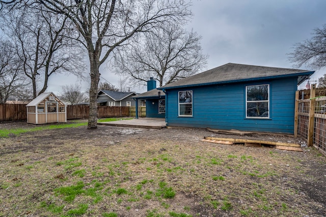 back of property featuring an outdoor structure and a patio area