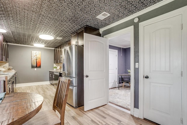 kitchen featuring stainless steel refrigerator with ice dispenser, dark brown cabinets, ornamental molding, and light wood-type flooring