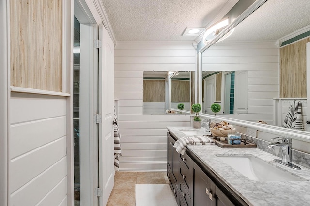 bathroom with vanity, wooden walls, and a textured ceiling